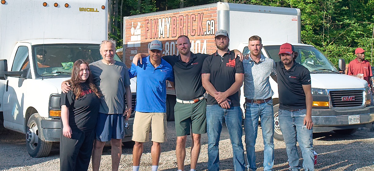 Fix My Brick team in front of service trucks