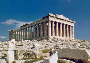 This image depicts the Parthenon an ancient Greek temple located on the Acropolis in Athens Greece The Parthenon is a well-preserved example of classical Greek architecture with its distinctive columns and pediments The temple is constructed of white marble and stands atop a raised platform surrounded by ancient ruins and debris The sky is a vibrant blue providing a striking contrast to the warm-toned stone of the Parthenon This iconic structure is a renowned symbol of ancient Greek civilization and a popular tourist destination