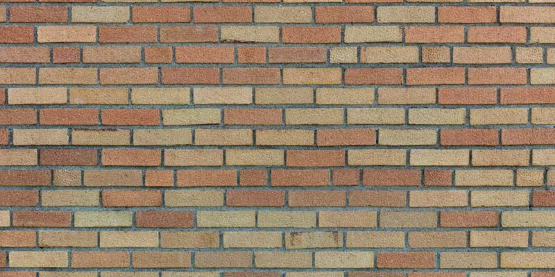 This image shows a brick wall with a repeating pattern of rectangular bricks in various shades of beige, tan, and brown. The bricks are arranged in rows, with some variation in the color and texture of the individual bricks. The overall appearance of the wall is uniform and structured, creating a visually appealing texture.