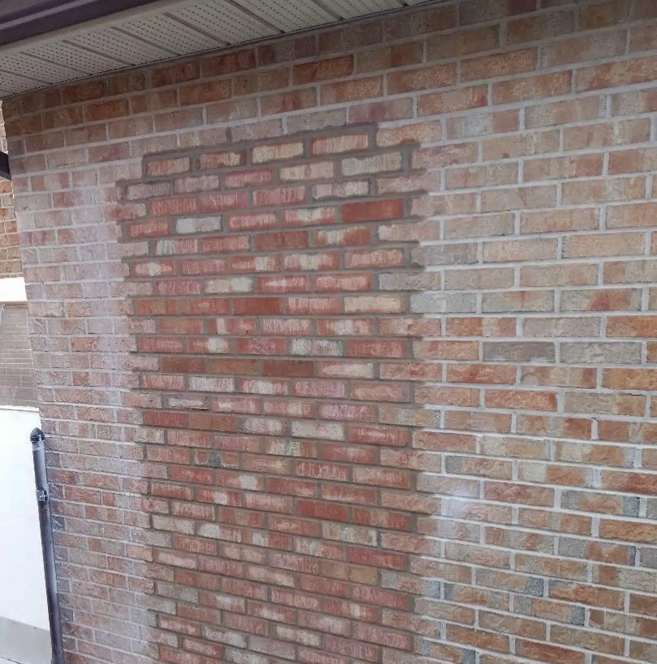 This image shows a brick wall The bricks are a mix of reddish-brown and light tan colors creating a textured and varied appearance The bricks are laid in a typical running bond pattern with some variation in the size and placement of the bricks The wall appears to be part of a building or structure and the image captures the detailed and intricate masonry work